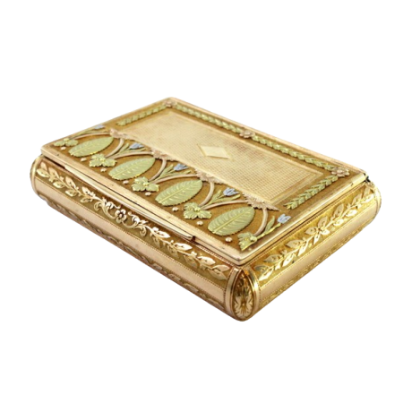 Caixa de rapé em ouro tricolor com palmas, motivos florais, grinaldas ricamente relevadas e cartela para monograma em forma de losangulo sobre a tampa basculante.